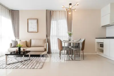 Modern open-plan living room and kitchen with elegant decor and natural light.