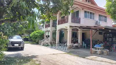 Charming two-story house with spacious driveway and lush greenery, perfect for family living.