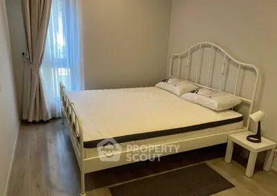 Cozy bedroom with elegant bed and natural light from window, perfect for relaxation.