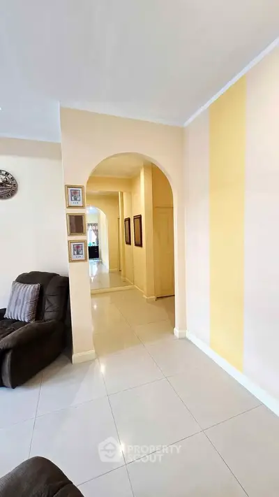 Spacious living area with elegant archway and cozy seating, perfect for relaxation and entertaining.