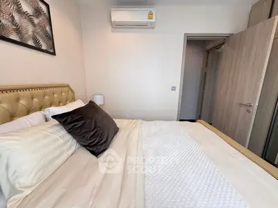 Cozy bedroom with plush bedding and modern air conditioning unit.