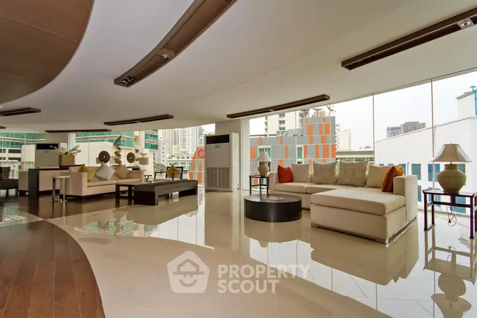 Luxurious modern living room with panoramic city views and elegant furnishings.