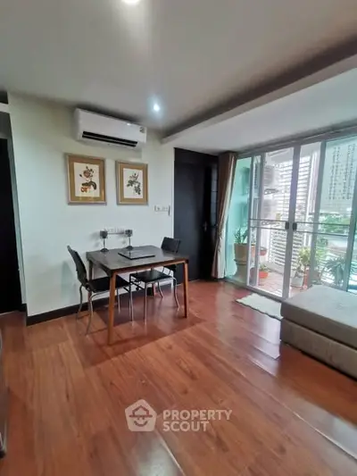 Modern living room with wooden flooring and balcony view in urban apartment