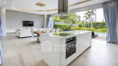 Luxurious open-plan kitchen and living room with pool view and modern design.