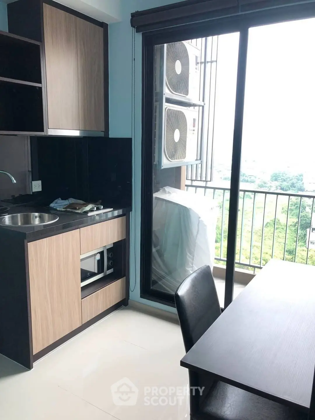 Modern kitchen with sleek cabinetry and balcony view in a stylish apartment.