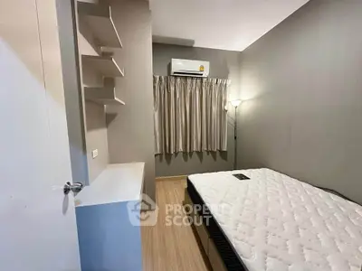 Cozy bedroom with modern design, featuring a comfortable mattress, air conditioning, and stylish shelving.