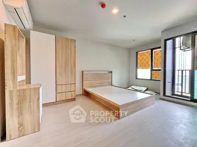 Spacious modern bedroom with large windows and wooden furniture