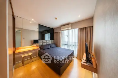 Modern bedroom with sleek design, featuring a comfortable bed, wooden flooring, and ample natural light.