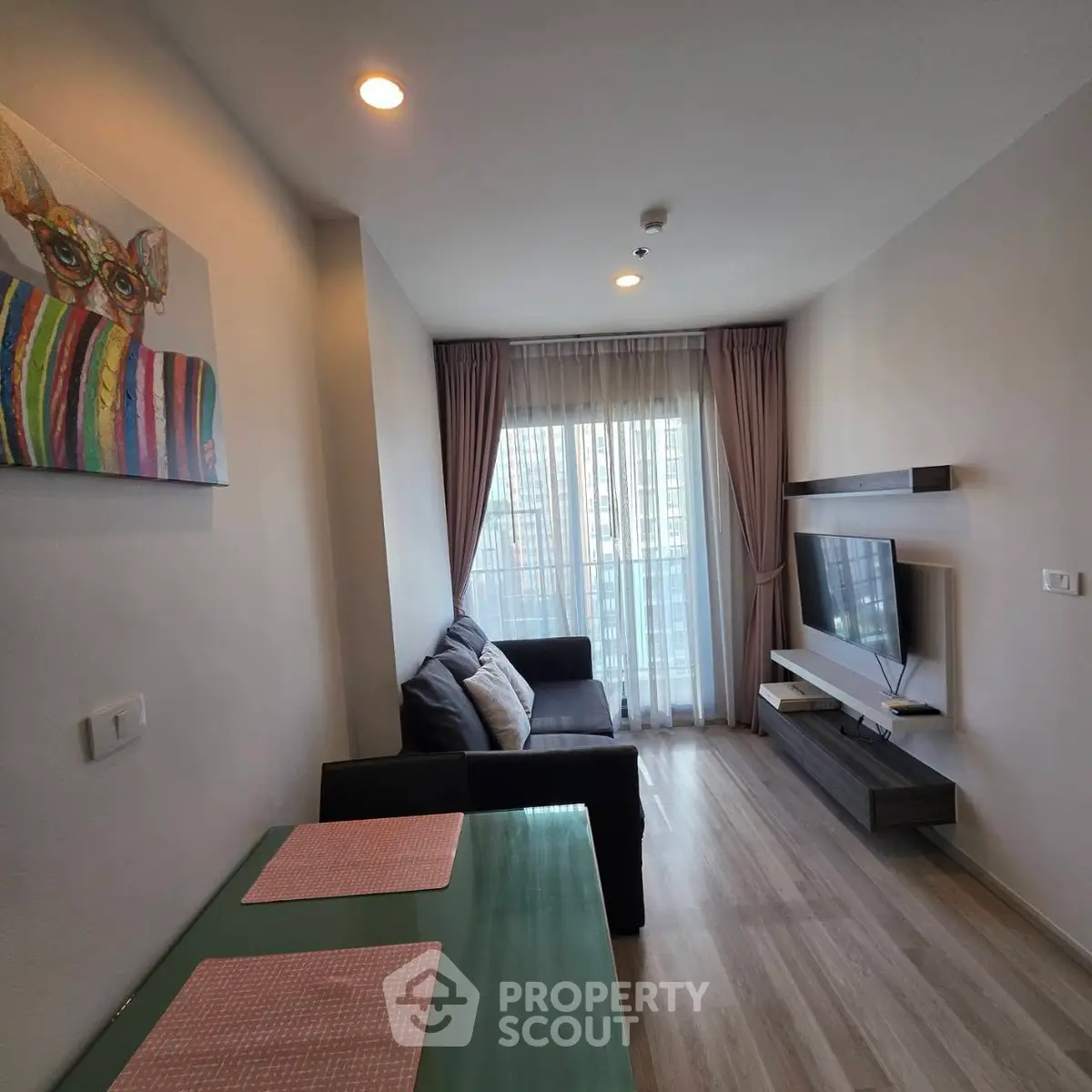 Modern living room with stylish decor and large window offering natural light.