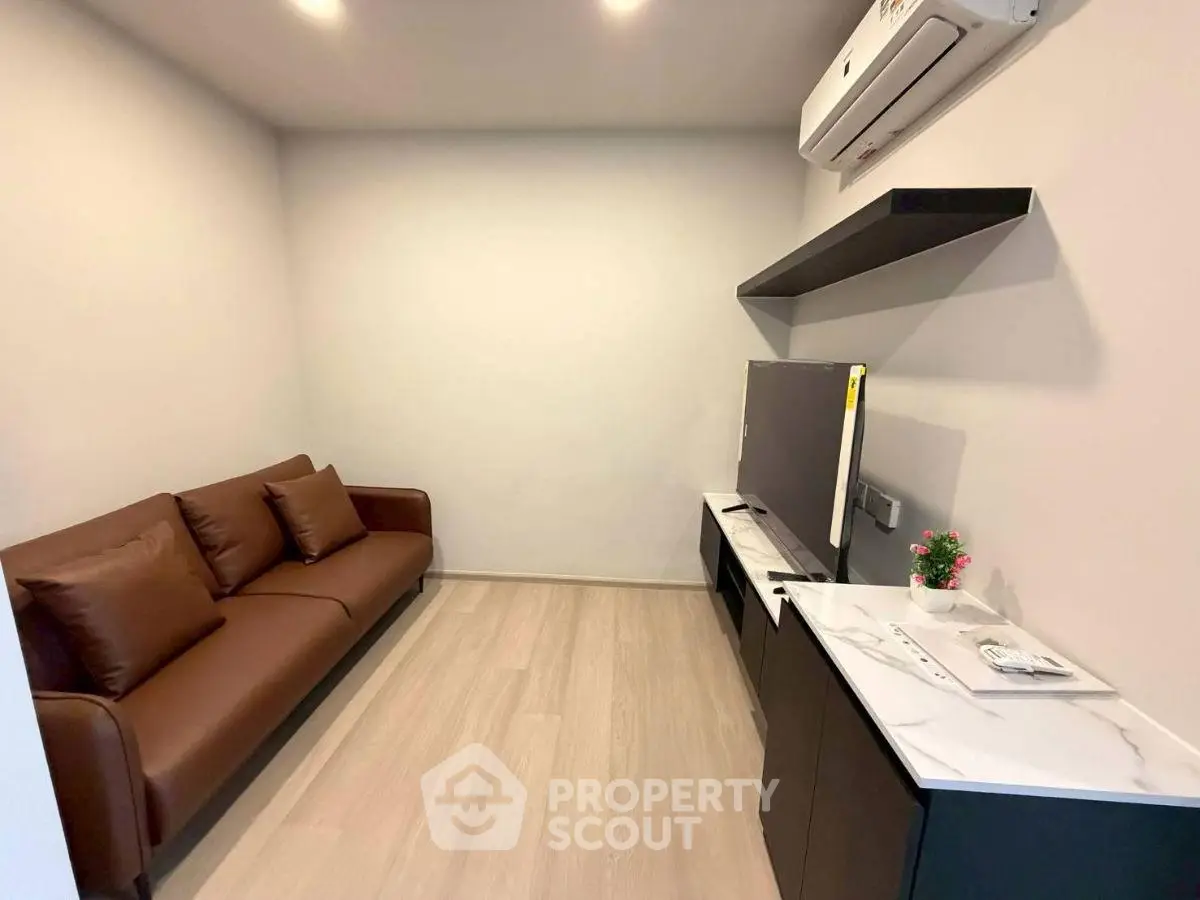 Modern living room with sleek brown sofa and wall-mounted air conditioner