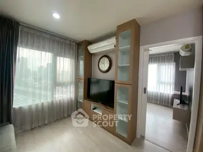 Modern living room with large window and built-in TV unit in stylish apartment