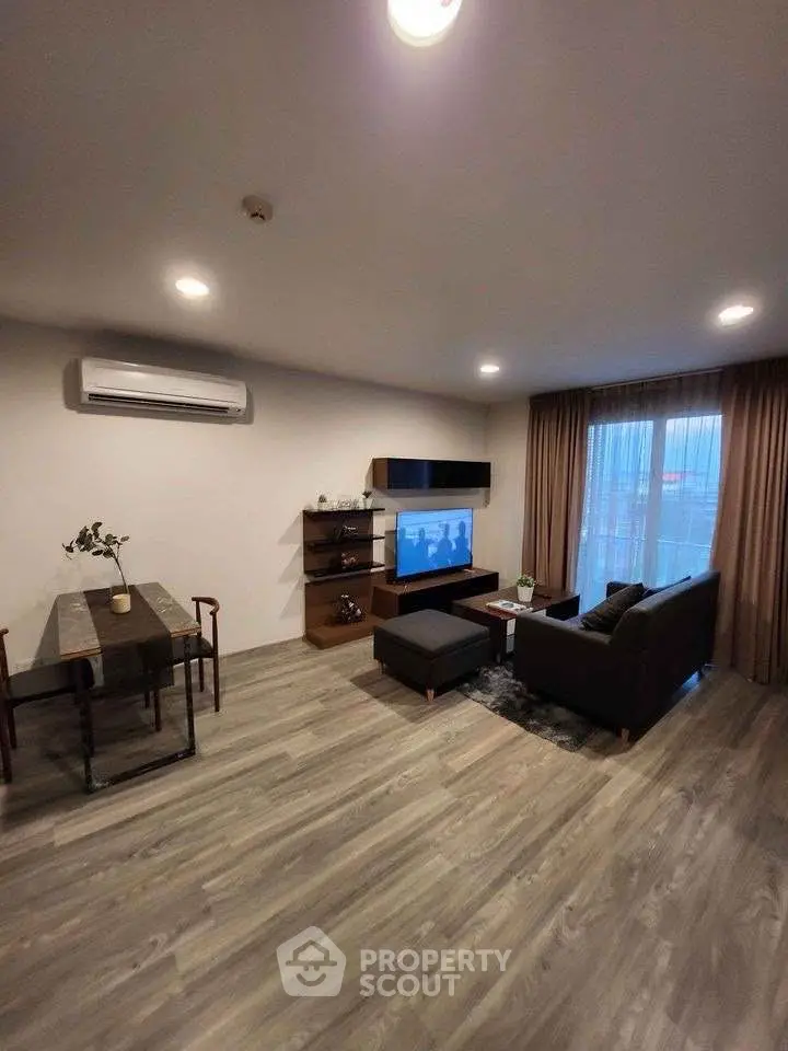 Modern living room with stylish furniture and large window, perfect for relaxation and entertainment.