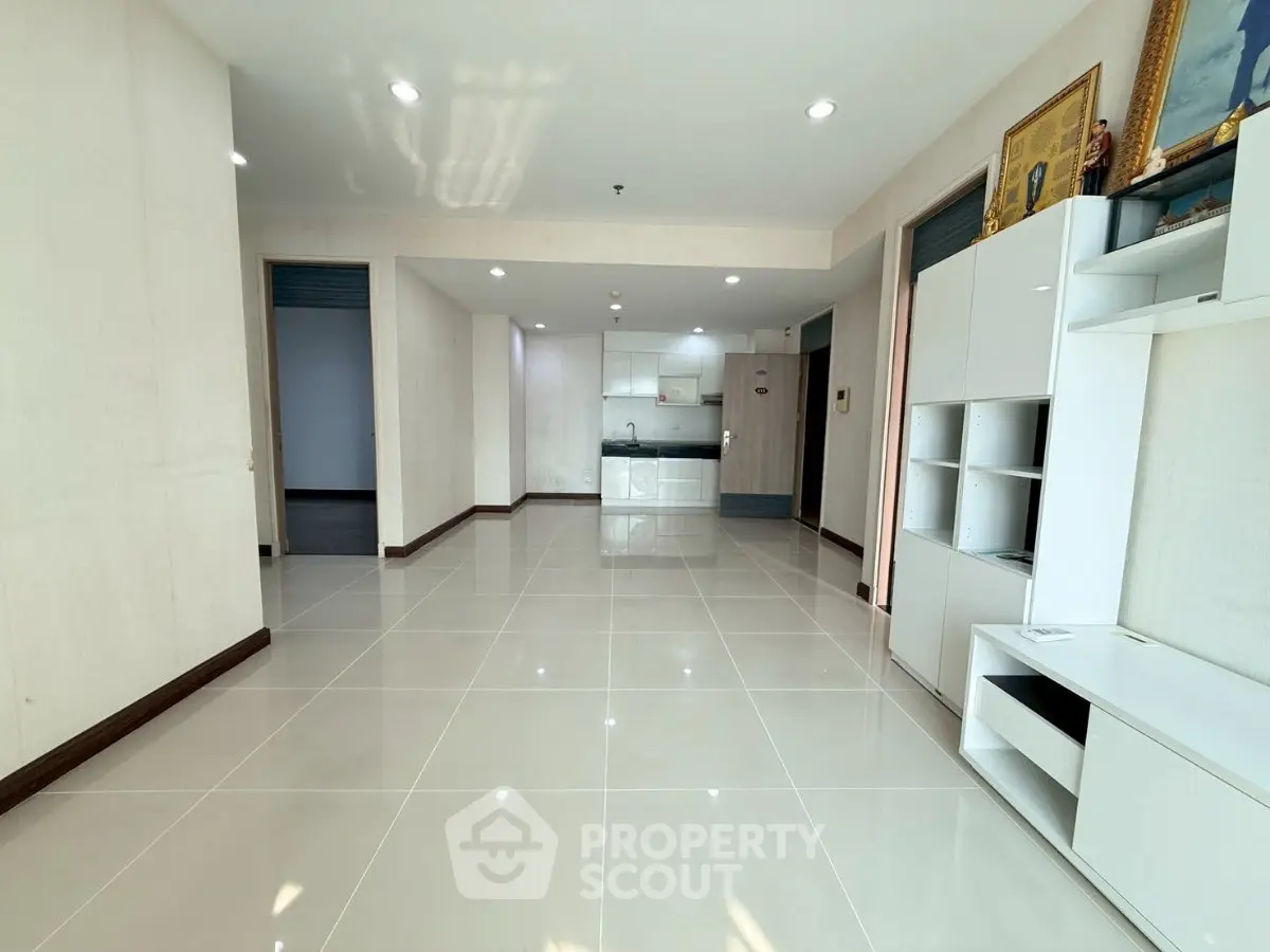 Spacious modern living room with open kitchen and sleek tile flooring