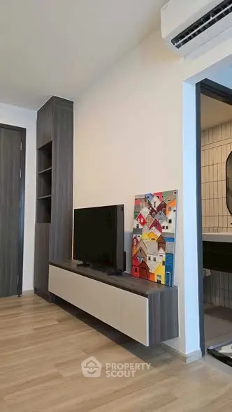 Modern living room with sleek TV unit and air conditioning, showcasing contemporary design and comfort.