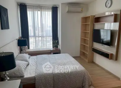 Modern bedroom with stylish decor, featuring a large window, air conditioning, and wall-mounted TV.