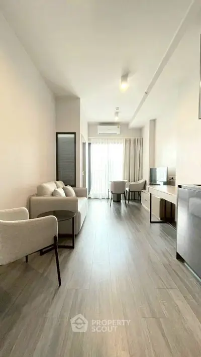Spacious modern living room with sleek furniture and natural light, perfect for relaxation and entertainment.