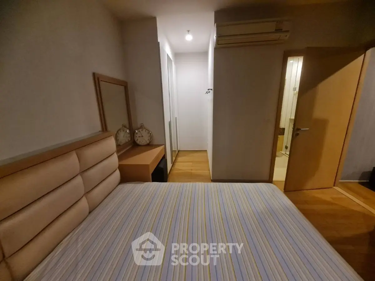 Cozy bedroom with modern furnishings and ample closet space in a stylish apartment.