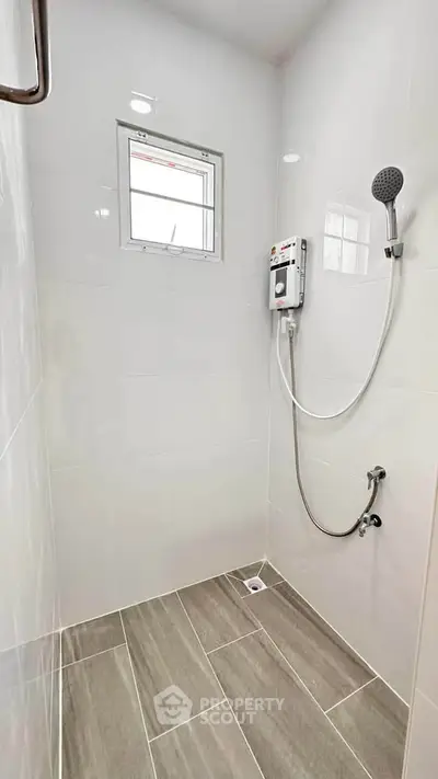 Modern bathroom with sleek shower and tiled flooring, perfect for a contemporary home.