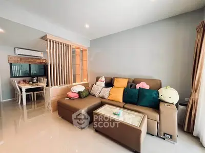 Modern living room with cozy sofa and dining area in open layout apartment.