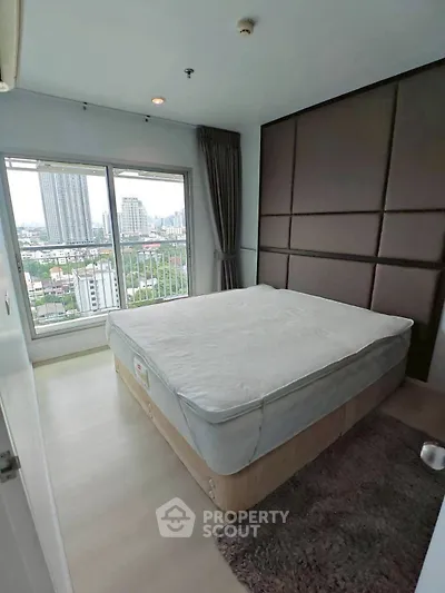 Modern bedroom with city view and large window in high-rise apartment