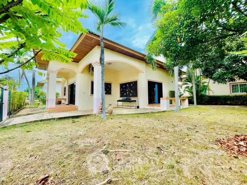 Charming single-story home with lush garden and spacious patio, perfect for outdoor living.