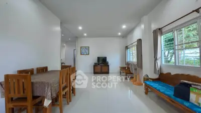 Spacious living room with wooden furniture and large windows in a modern home.