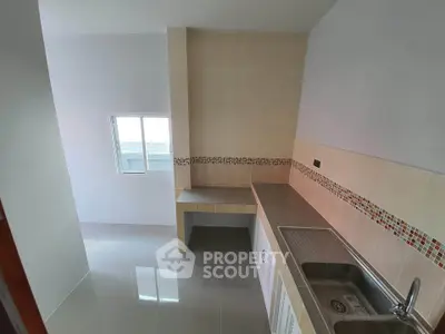 Modern kitchen with sleek countertops and tiled backsplash, featuring a compact and efficient design.