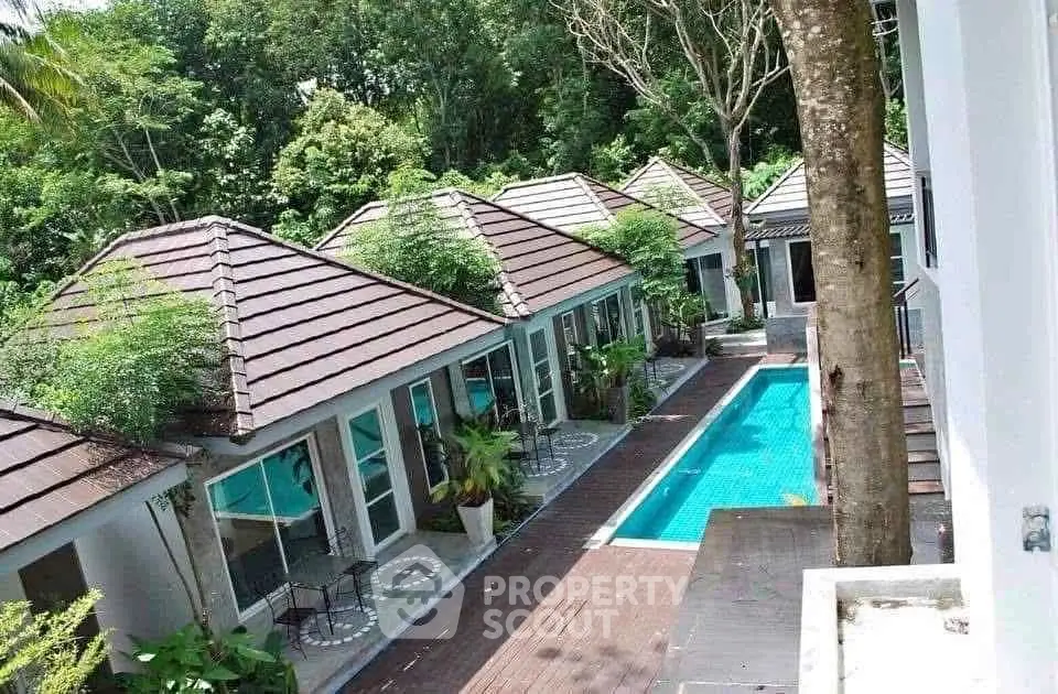Charming villa complex with private pool surrounded by lush greenery, perfect for serene living.