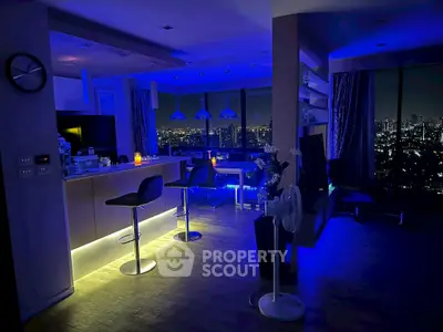 Stunning modern living room with city skyline view, ambient lighting, and sleek bar seating.