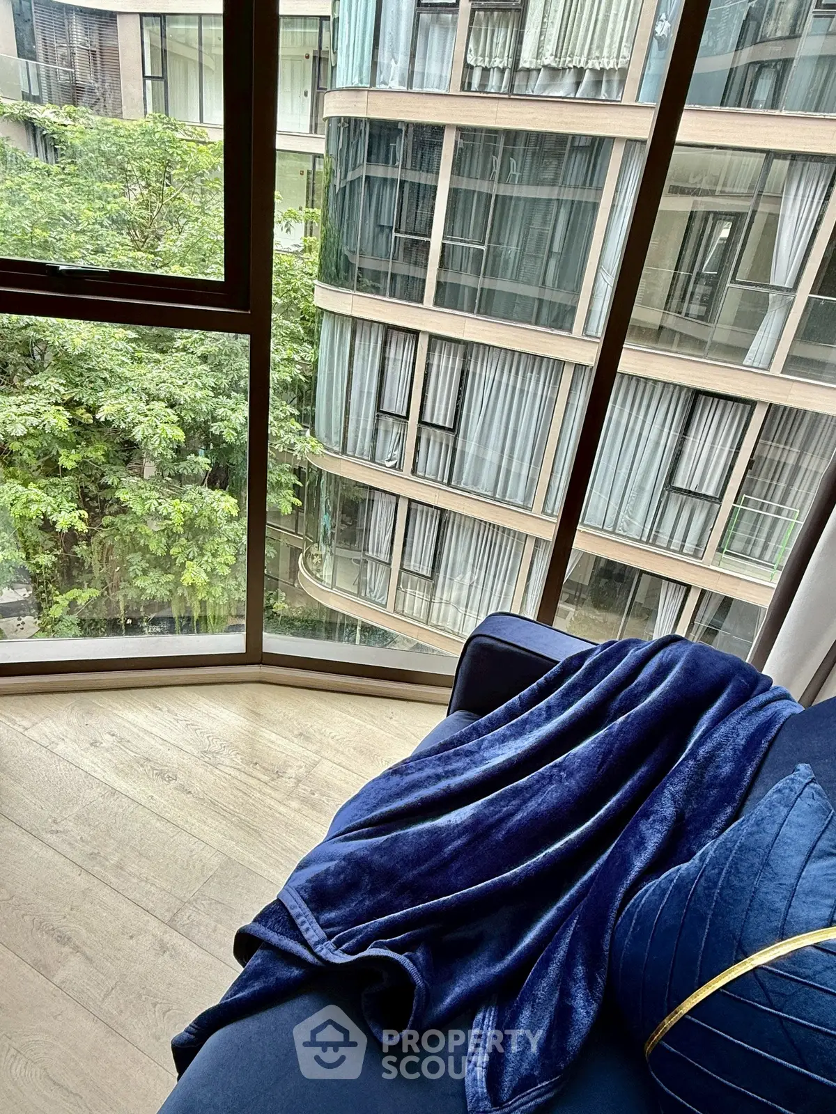 Luxurious apartment with floor-to-ceiling windows offering stunning city views and elegant interior design.