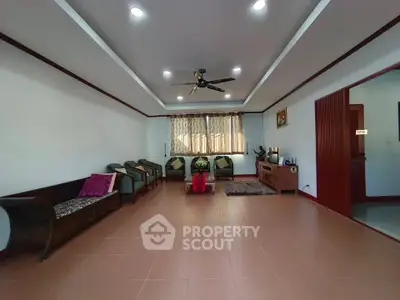 Spacious living room with modern ceiling fan and elegant seating arrangement.
