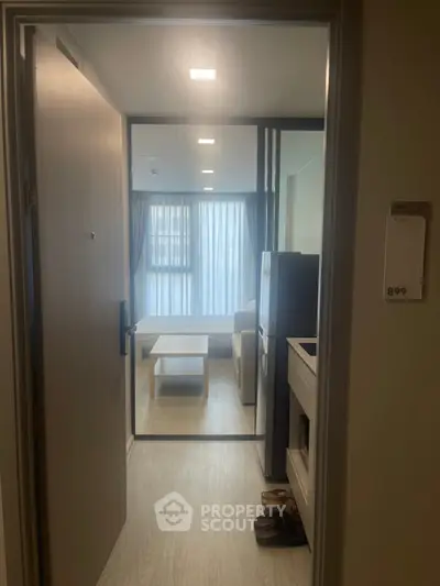 Modern apartment entrance leading to a cozy living room with natural light and stylish decor.