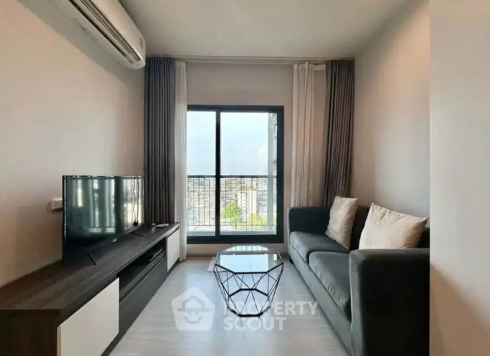 Modern living room with sleek furniture and large window offering city view.