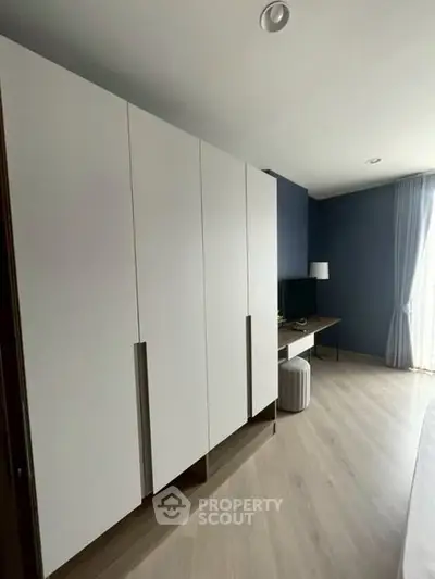 Modern bedroom with sleek wardrobe and natural light