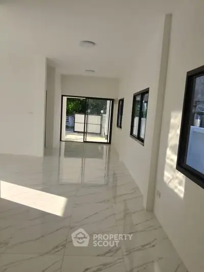 Spacious modern interior with marble flooring and large windows for natural light.