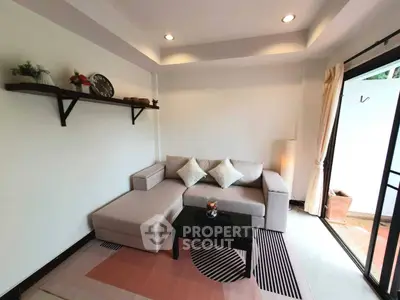 Modern living room with stylish sofa and open balcony access, perfect for relaxation and entertaining.
