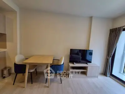 Modern living room with dining area and TV setup in a cozy apartment.