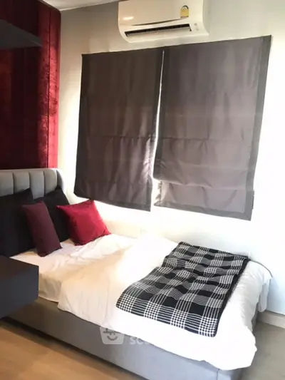 Cozy bedroom with modern decor and air conditioning, featuring a stylish bed and elegant curtains.