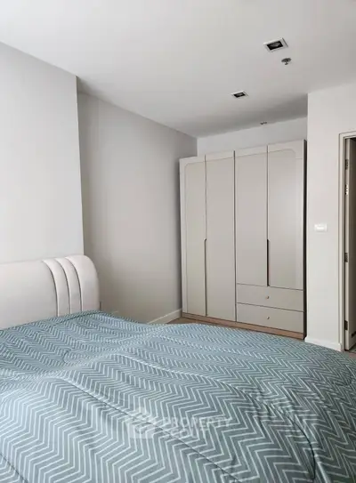 Modern bedroom with stylish wardrobe and cozy bedding in a contemporary apartment.