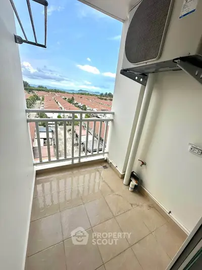 Charming balcony with stunning view of rooftops and clear blue sky.