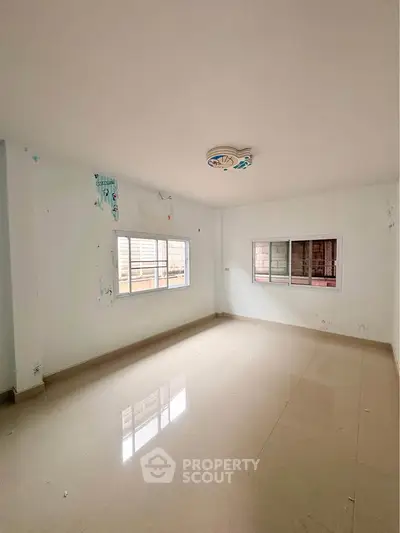 Spacious empty room with large windows and glossy tiled floor, perfect for customization.