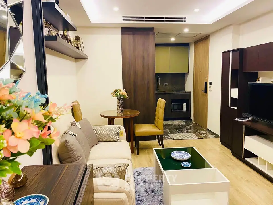 Chic modern living room with cozy seating and stylish decor, featuring a compact kitchen area in an open layout.