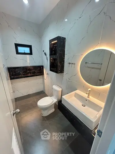 Luxurious modern bathroom with elegant marble finishes and stylish lighting.