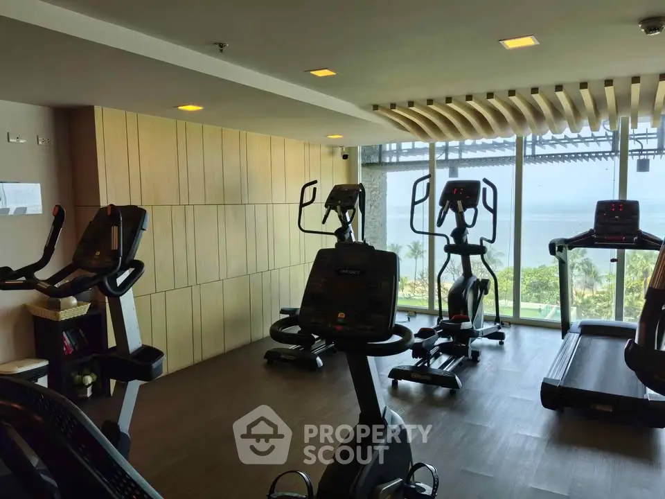 Modern gym with exercise equipment and ocean view in luxury real estate property.