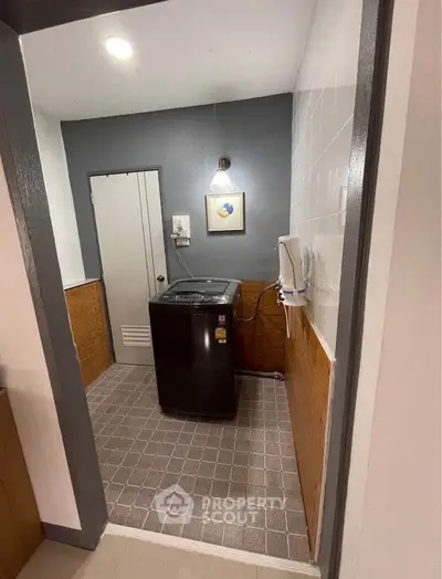 Compact laundry room with modern washing machine and stylish decor.