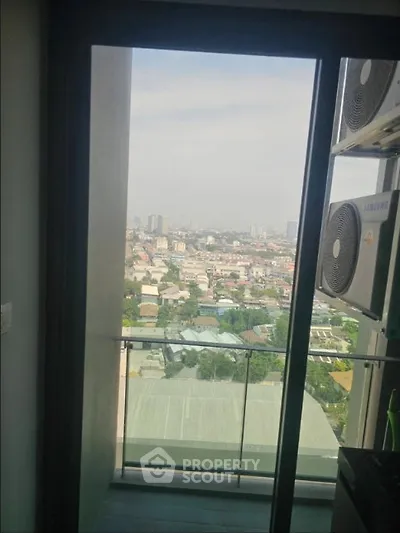 Stunning city view from a high-rise balcony with modern air conditioning units.