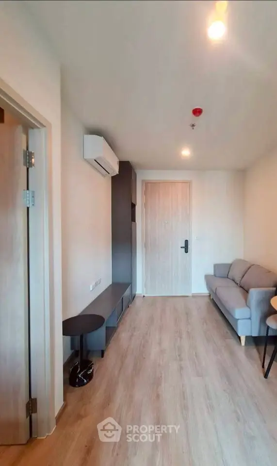 Modern living room with sleek design, featuring a cozy sofa and stylish wooden flooring.