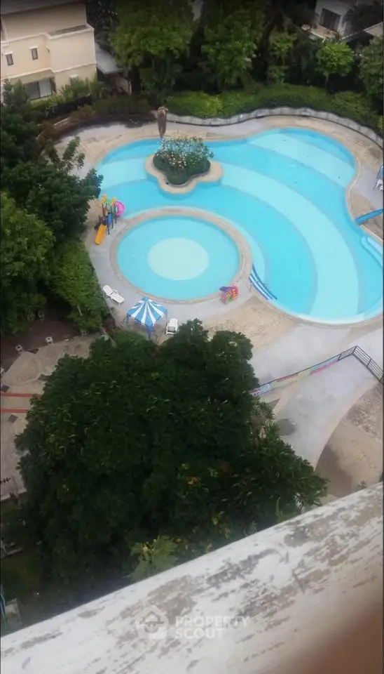 Stunning aerial view of a luxurious swimming pool surrounded by lush greenery, perfect for relaxation and leisure.