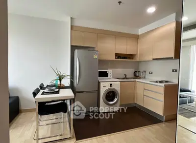 Modern kitchen with sleek appliances and dining area in stylish apartment