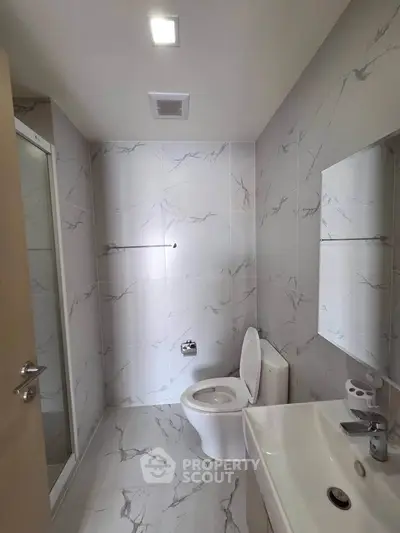 Modern bathroom with marble tiles and sleek fixtures in a contemporary apartment.